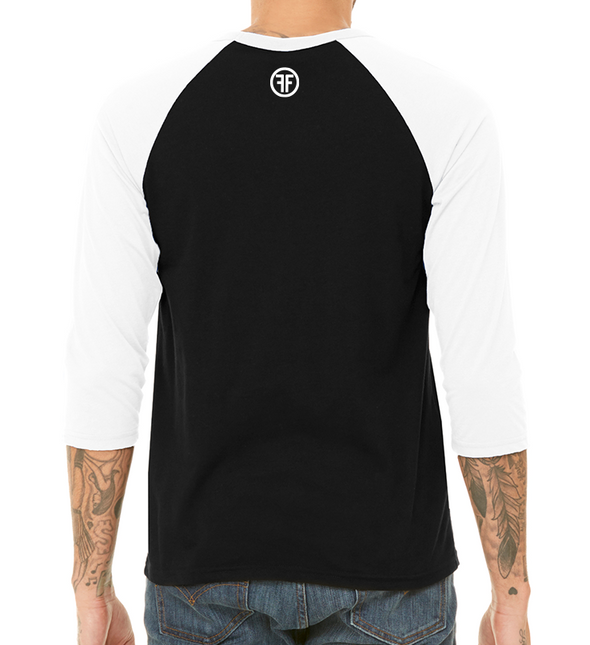 back of male model wearing the USA fifty50 raglan by fifty50 apparel which is a black and white raglan with a white logo near the neckline