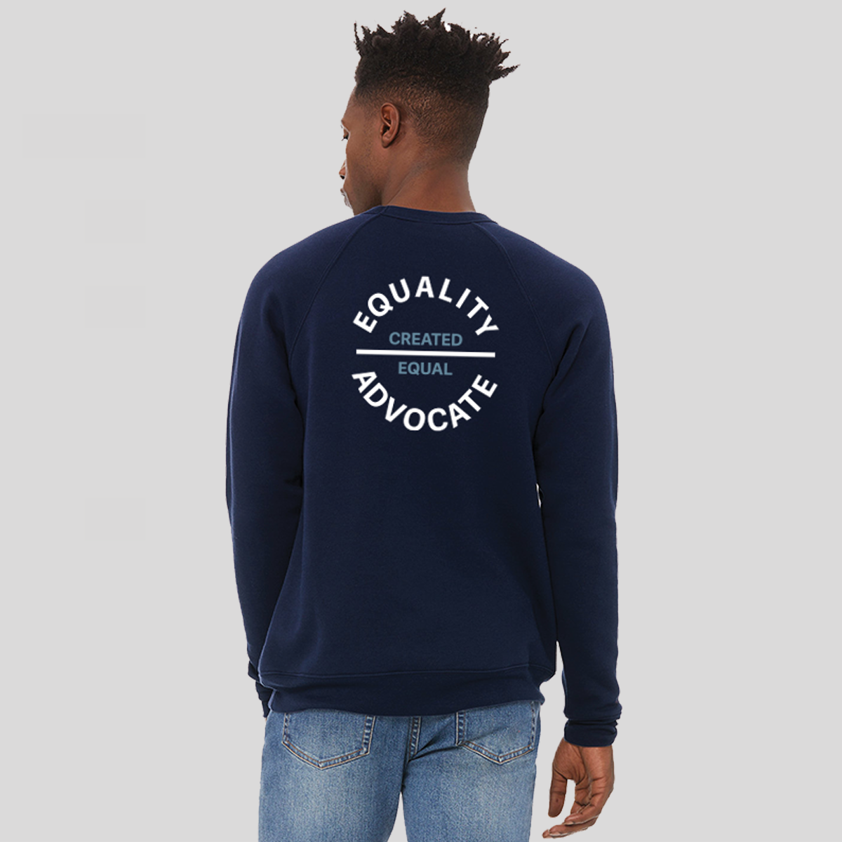 Back of man wearing in a navy blue equality crew sweatshirt with a left chest, circular logo. The text Equality Advocate is in white, bold font, and the text Created Equal is in Slate Blue, bold font.