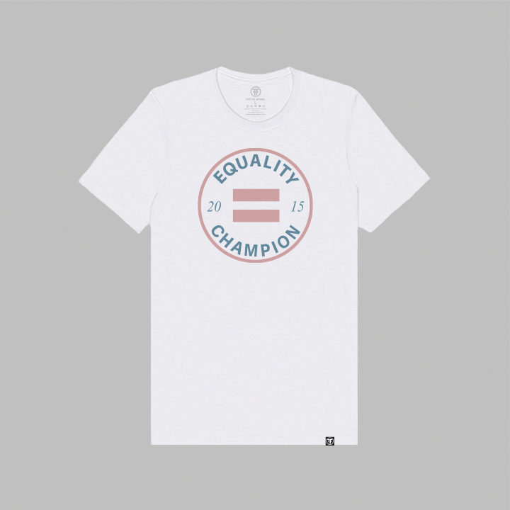 A white equality tshirt with a large, round logo center chest. The circle and Fifty 50 Apparel logo are in Dusty Rose ink, while the text Equality Champion and the date 2015 are in Slate Blue.