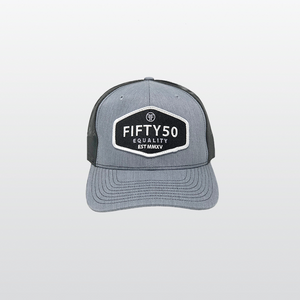 A grey equality trucker hat with black mesh back panels. The hexagon black patch has the text in white, bold font, Fifty50, Equality and the date, 2015, in Roman numerals.