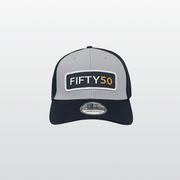 A fitted hat with grey front panels and a black bill and side panels. The patch is a thin rectangle with the text Fifty50 in bold white and orange.