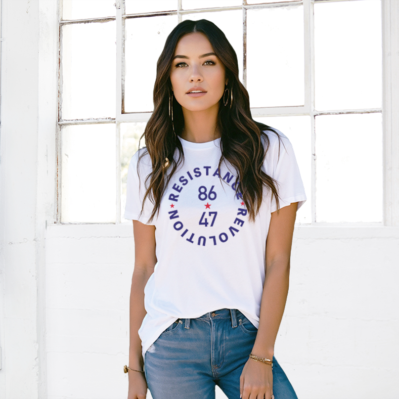 A lady wearing a white t-shirt with the navy blue bold text, 86 47 in the middle. 
In a circle, around that, is navy blue, bold font text, Resistance Revolution. There are 3 small red stars between the text.