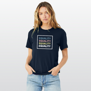 Lady wearing a navy blue equality tshirt with the text Equality, stacked four times in a row, in Slate Blue, Dusty Rose, Bisque Gold, and white. The text is in bold font and is outlined by a white square.  