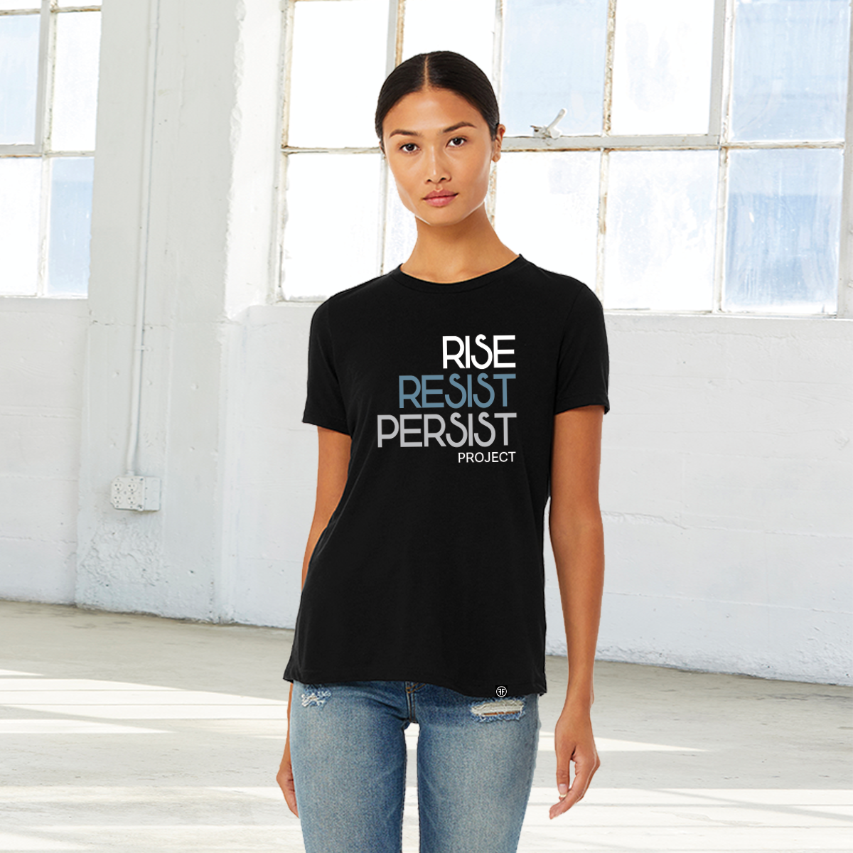 A lady wearing a political unisex black t-shirt. The text says Rise, Resist, Persist, Project. The font is white, Slate Blue, and grey.