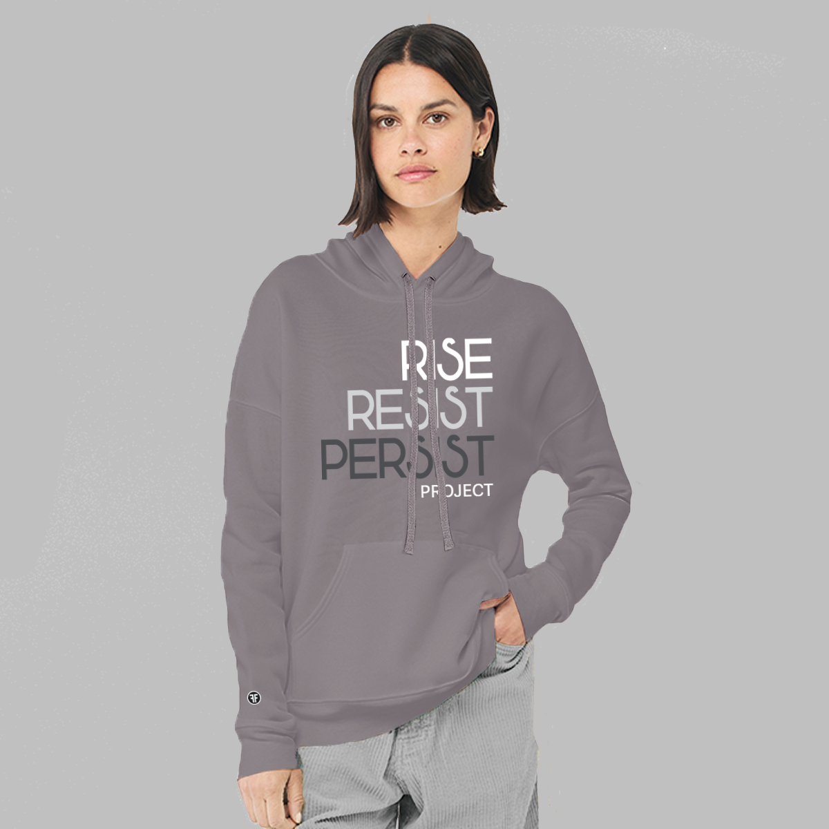 A lady wearing a slate purple, unisex anti Trump hoodie. The text says Rise, Resist, Persist Project in white, light grey and dark grey.