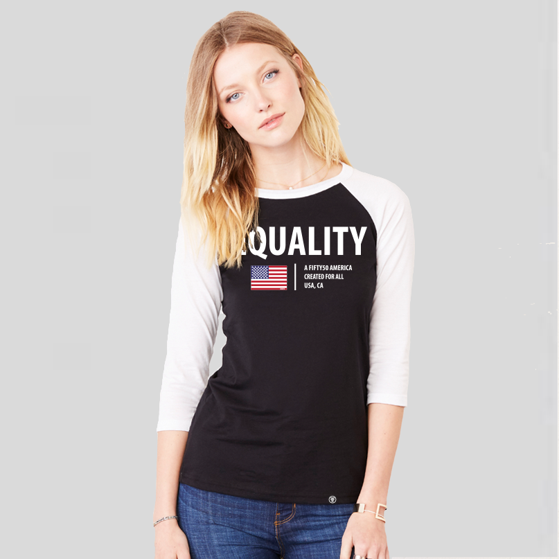 A lady wearing a black baseball t-shirt with white arms and collar. The logo has the text, Equality, written in white bold font, and an American flag and the text, A fifty 50 America created for all.