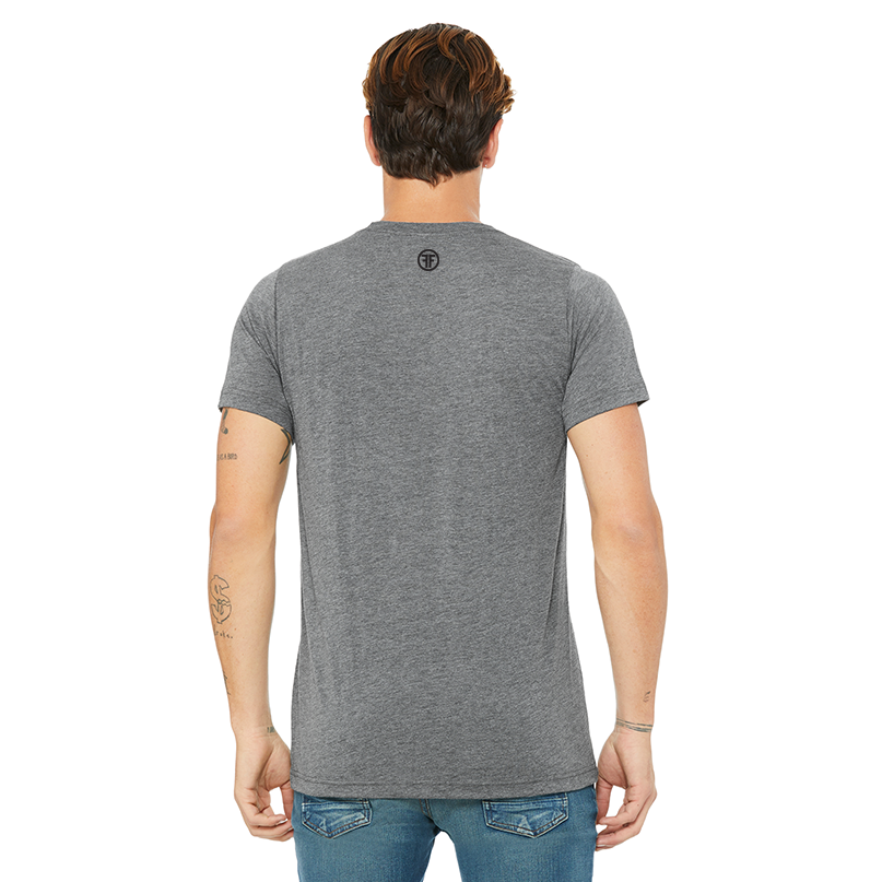 The back of a man in a charcoal grey tshirt to show the fit with a small black logo. The logo is two black Fs, back to back, outlined by a circle.