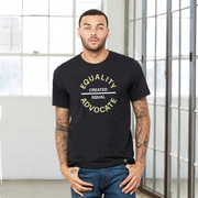 Man wearing a black equal rights t shirt with a large center chest logo. The text Equality Advocate is in Bisque Gold, bold font, while the text Created Equal, is in bold white.