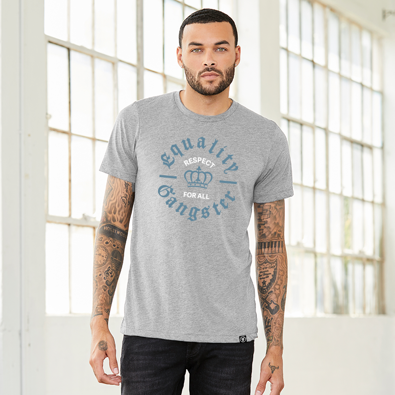 Man wearing a light grey equality tshirt with the text, Equality Gangster in grey Old English font. A grey crown is in the center, and in between is the text, Respect for All, in Slate Blue bold font.