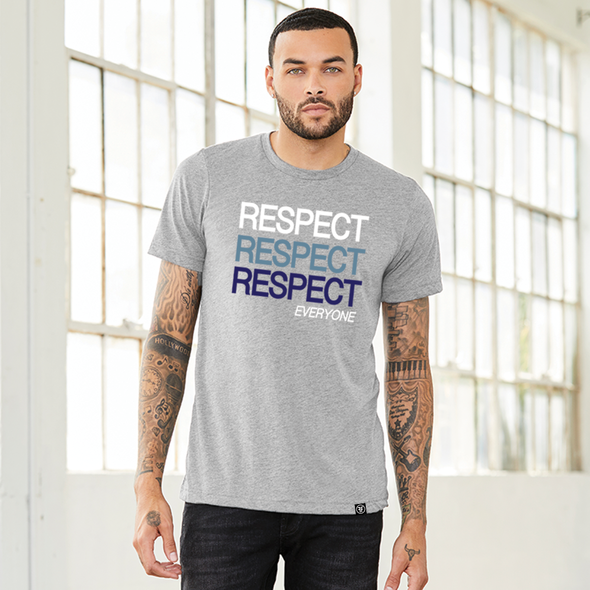 A man wearing a grey unisex political t-shirt with text Respect Everyone. Respect is written in bold font in white, Slate Blue, and navy blue. 