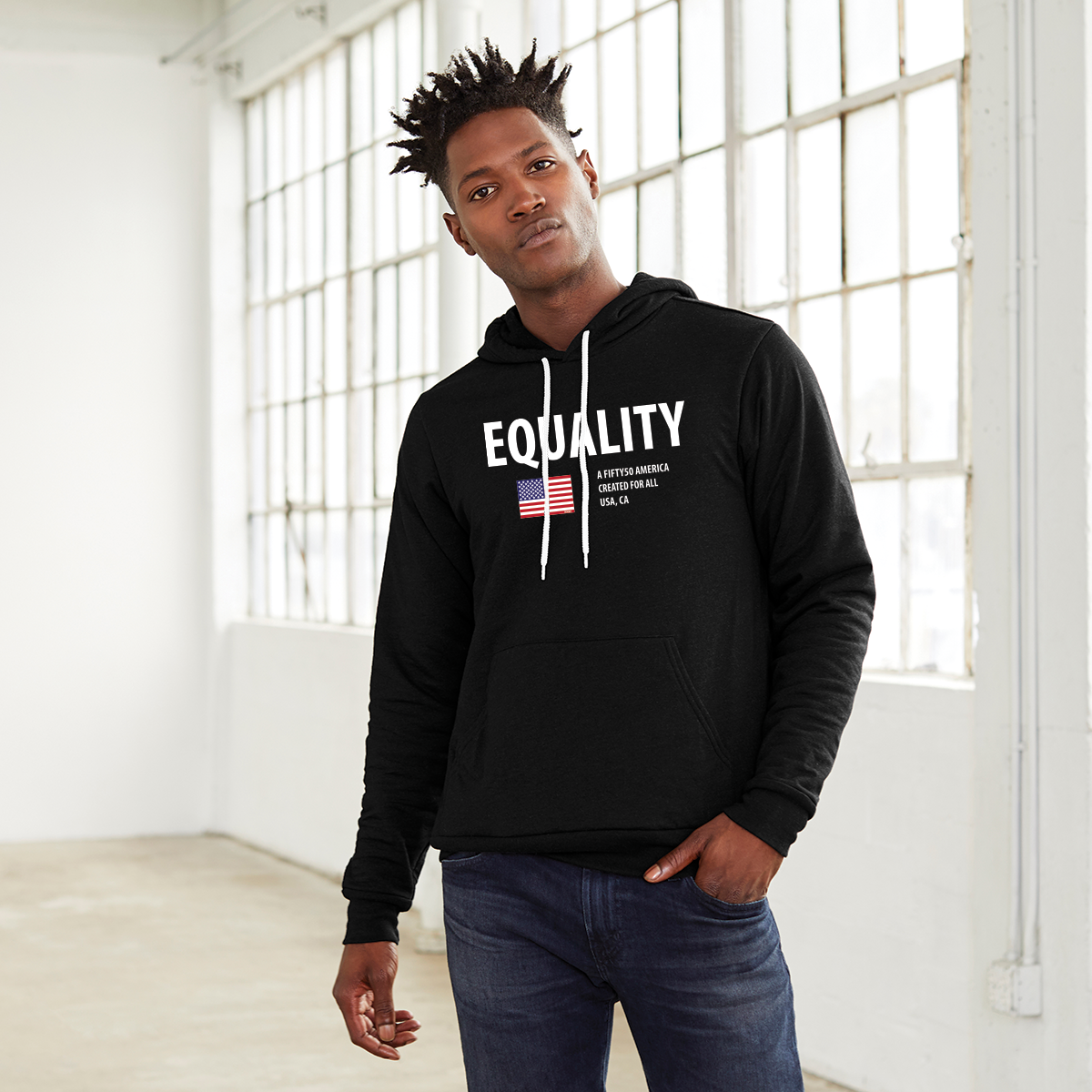 A man wearing a black hoodie. The logo has the text, Equality, written in white bold font, and an American flag and the text, A fifty 50 America created for all.