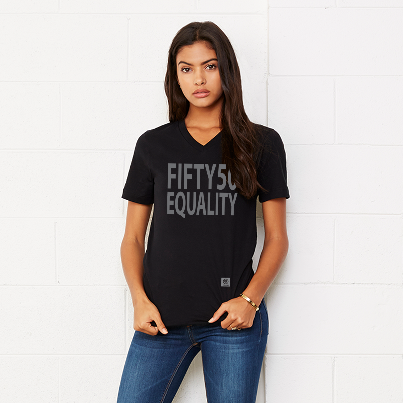 A lady wearing a black v-neck equality tshirt. The text is in large, grey, bold font and says Fifty50 with Equality below it. 