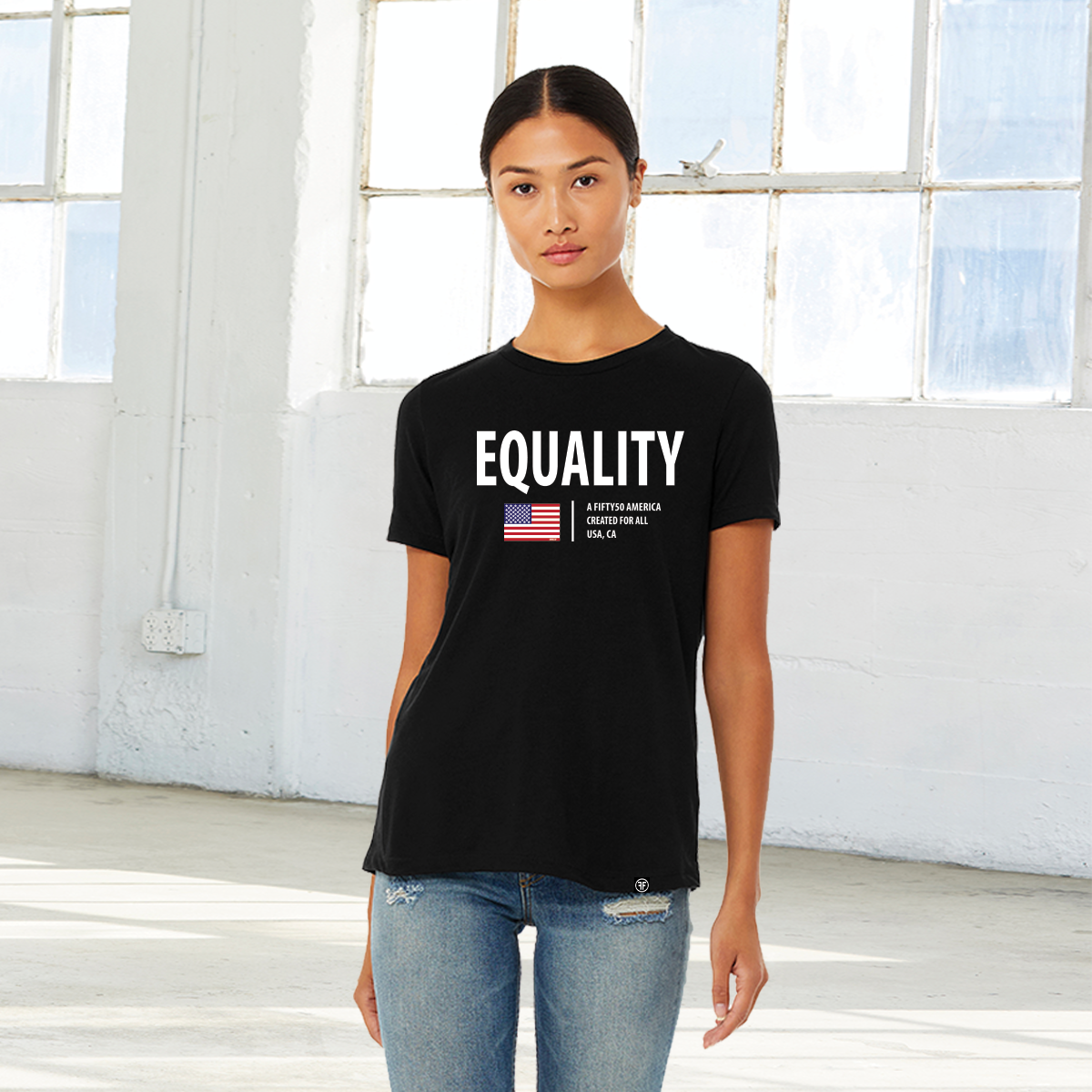 A lady wearing a black t-shirt. The logo has the text, Equality, written in white bold font, and an American flag and the text, A fifty 50 America created for all.